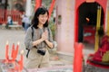 Portrait of asian woman saying prayers and eyes close in front of local Chinese shrine in Bangkok, Thailand Royalty Free Stock Photo