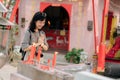 Portrait of asian woman saying prayers and eyes close in front of local Chinese shrine in Bangkok, Thailand