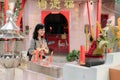 Portrait of asian woman saying prayers and eyes close in front of local Chinese shrine in Bangkok, Thailand