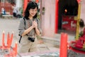 Portrait of asian woman saying prayers and eyes close in front of local Chinese shrine in Bangkok, Thailand Royalty Free Stock Photo