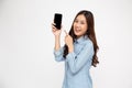 Portrait of Asian woman showing or presenting mobile phone application and pointing finger to smartphone.