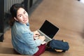 Portrait asian woman sitting, using laptop, smiling and looking at camera. Royalty Free Stock Photo