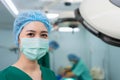 Portrait of Asian woman surgeon with medical mask standing in operation theater at a hospital. Team of Professional surgeons. Royalty Free Stock Photo