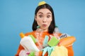 Portrait of asian woman with surprised face, holds plastic empty bottles and garbage for recycling, sorting stations