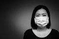 Portrait of Asian woman using surgical mask for protecting COVID-19 or epidemic disease. Black and white tone