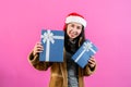 portrait, Asian woman wearing long-sleeved outerwear and Christmas hat, holding two gift boxes with two hands Royalty Free Stock Photo