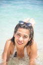 Portrait of Asian woman wearing white swimsuit and wear sunglasses lying on a sandy beach Royalty Free Stock Photo