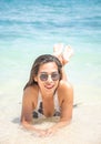 Portrait of Asian woman wearing white swimsuit and wear sunglasses lying on a sandy beach Royalty Free Stock Photo