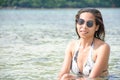 Portrait of Asian woman wearing white swimsuit and wear sunglasses lying on a sandy beach Royalty Free Stock Photo