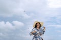 Portrait of Asian woman with white straw hat standing at beach smiling young woman on vacation enjoying the sea breeze wearing a Royalty Free Stock Photo