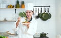 Portrait of Asian young beautiful chef woman wear white chef uniform and hat, holding spaghetti dish, smiling looking at camera Royalty Free Stock Photo