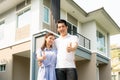 Portrait of Asian young couple standing, hugging and showing thumb up together looking happy in front of their new house to start Royalty Free Stock Photo