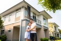 Portrait of Asian young couple standing and hugging together looking happy in front of their new house to start new life. Family, Royalty Free Stock Photo