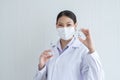 Portrait of Asian young doctor or scientist woman holding showing Covid-19 vaccines vial bottle in hand with face mask, syringe Royalty Free Stock Photo