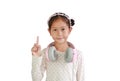 Portrait of Asian young girl kid with headphones on neck show one forefinger isolated on white background Royalty Free Stock Photo