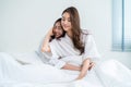 Portrait of Asian young lesbian couple sit on bed and hug each other. Attractive romantic girl friend in pajamas spending morning Royalty Free Stock Photo