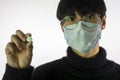 Chinese young man in medical mask, pill in hand. Prevent spread of coronavirus Royalty Free Stock Photo