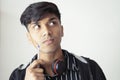 Portrait of asian young man good grooming holding pen looking sideways with doubtful expression Royalty Free Stock Photo