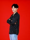 Portrait asian young man about 20-25 years old standing while folded arms crossed and looking at camera with feel confident and Royalty Free Stock Photo