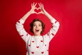 Portrait of astonished girl make heart hands enjoy passionate love sign look impressed scream wow omg wear white jumper