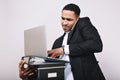 Portrait astonished oficce worker holding folders, laptop talking on phone on white background. Stylish businessman