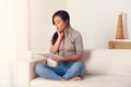 Astonished Woman reading a book on couch at home