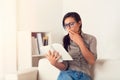 Astonished Woman reading a book on couch at home