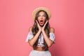 Portrait of astonished woman 20s wearing straw hat raising hands