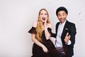 Portrait astonished young woman with long blonde hair in luxury dress with joyful handsome guy having fun in tinsels on