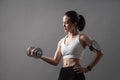 Portrait athlete Asian active woman workout with dumbbell weightlifting in studio grey background
