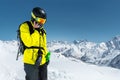 Portrait of an athlete skier wearing a helmet and a mask talking on the phone high in the mountains of the Caucasus