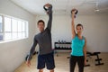 Portrait of athletes lifting kettlebells in gym Royalty Free Stock Photo