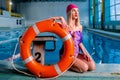 Portrait of athletic beautiful attractive blonde woman lifeguard with stylish make up in swim caps and swim suit