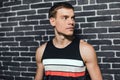 Portrait of athletic Caucasian man resting after fitness exercise. Sporty male standing against a brick wall. Sport, lifestyle, Royalty Free Stock Photo