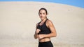 Portrait, athletic girl in a black top, athlete, practice kicks, kicks feet in front of the camera. On a deserted beach