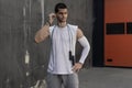 Portrait athletic man getting ready to rope jumping while firing earphones