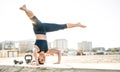 Portrait of athletic woman exercising calisthenic balance move at outdoors beach location - Modern alternative work out Royalty Free Stock Photo