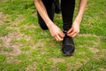 Portrait of an athletic woman tying her shoelaces and getting ready for jogging in public park . Sport and healthy lifestyle Royalty Free Stock Photo