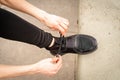 Portrait of an athletic woman tying her shoelaces and getting ready for jogging in public park . Sport and healthy lifestyle Royalty Free Stock Photo