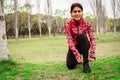 Portrait of an athletic woman tying her shoelaces and getting ready for jogging in public park . Sport and healthy lifestyle Royalty Free Stock Photo