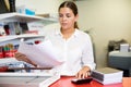 Portrait of an attentive woman checking quality of printing in printing house