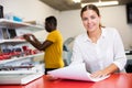 Portrait of an attentive woman checking quality of printing in printing house Royalty Free Stock Photo