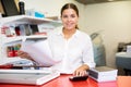 Portrait of an attentive woman checking quality of printing in printing house