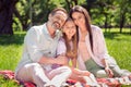 Portrait of attractive adorable affectionate cheerful family sitting in grass enjoying good weather sunny day picnic Royalty Free Stock Photo