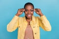 Portrait of attractive amazed cheerful girl touching specs news reaction isolated over bright blue color background