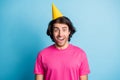 Portrait of attractive amazed delighted cheerful guy wearing yellow festal cap having fun isolated over bright blue