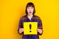 Portrait of attractive amazed girl holding yellow card sign isolated over bright yellow color background Royalty Free Stock Photo