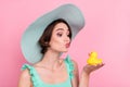 Portrait of attractive amorous funky girl holding yellow bath duck kissing isolated over pink pastel color background Royalty Free Stock Photo