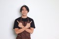 Portrait of attractive Asian barista man in brown apron showing product, pointing up right and left, showing two option of choices Royalty Free Stock Photo