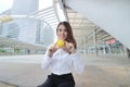 Portrait of attractive Asian business woman holding yellow ball in her hands at the city background. Royalty Free Stock Photo